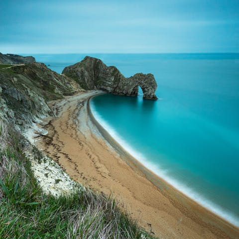 Visit Durdle Door's famous limestone arch, a nineteen-minute drive away