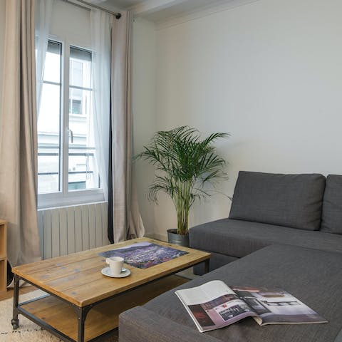Relax on the living room's sofa with a glass of French wine after a day of exploring the city
