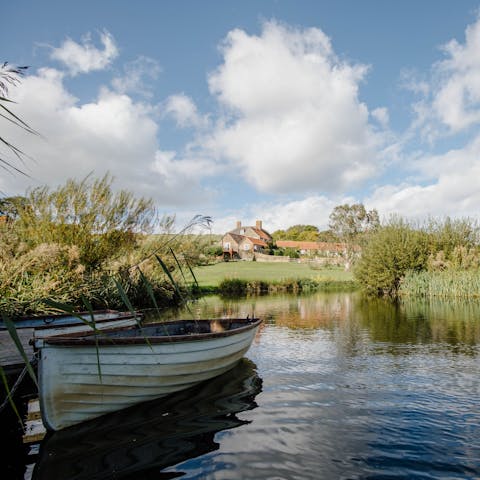 Take turns rowing on the farm's reed-lined lake