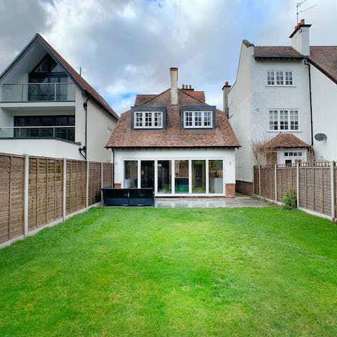 Play catch with the kids on the spacious lawn in the back garden