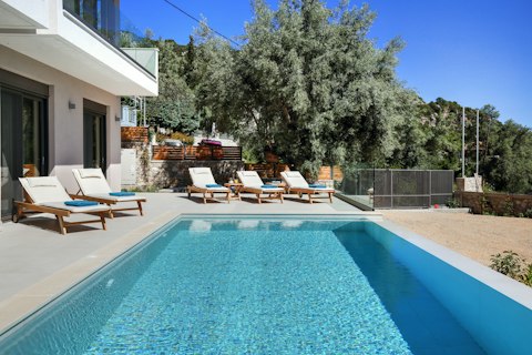Stretch out by the pool beneath open Greek skies