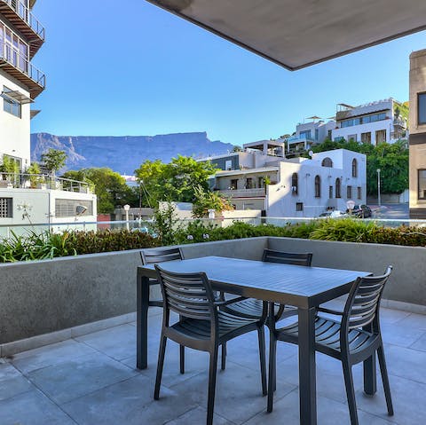 Gather round the outdoor dining table for dinner, enjoying the clear view of Table Mountain