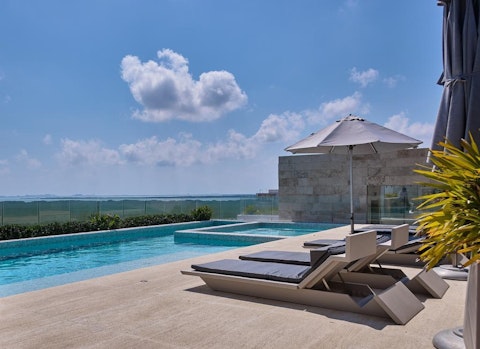 Swim laps in the communal pool with open water stretching to the horizon