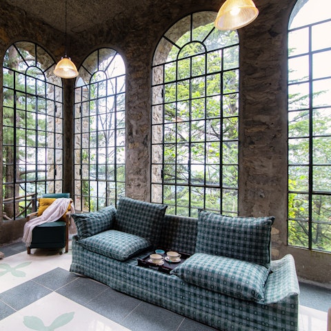 Curl up with a book in the conservatory, surrounded by majestic trees