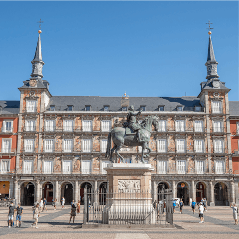 People watch from a cafe in the bustling Plaza Mayor