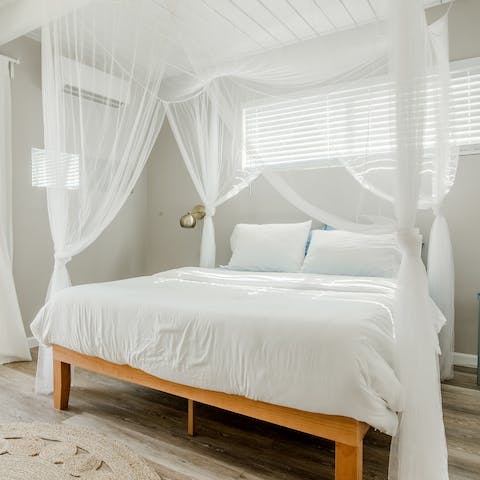 Wake up to the dreamy drapes of the four-poster bed