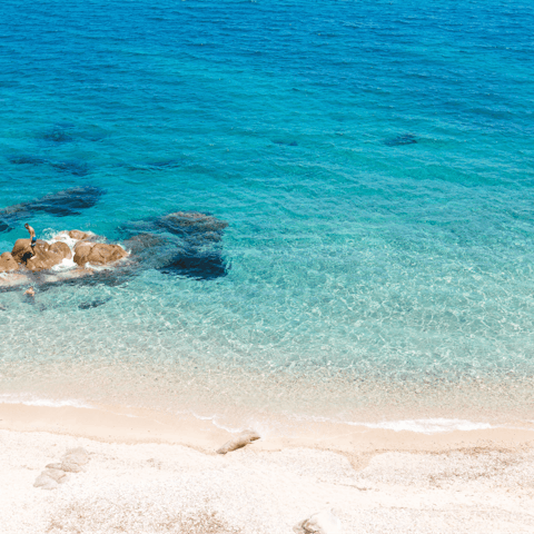Immerse yourself in the blue waters of the Agios Ioannis beach, nine minutes by car