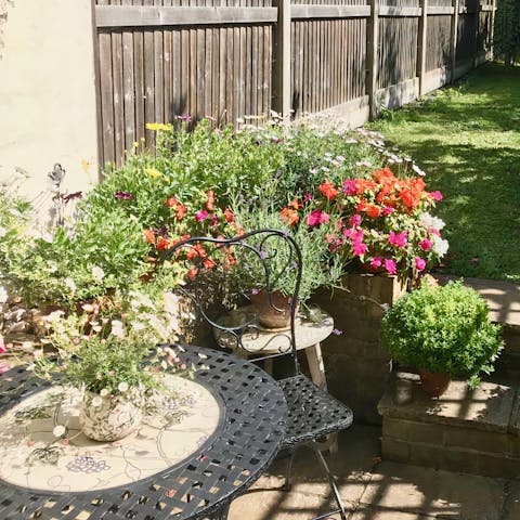 Enjoy your coffee with the morning sun on your face beside the roses