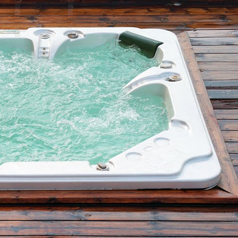Relax with a glass of something bubbly in hand in the covered hot tub