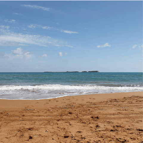 Sink your feet into the red sand at Xi Beach, just 2.5km from the villa