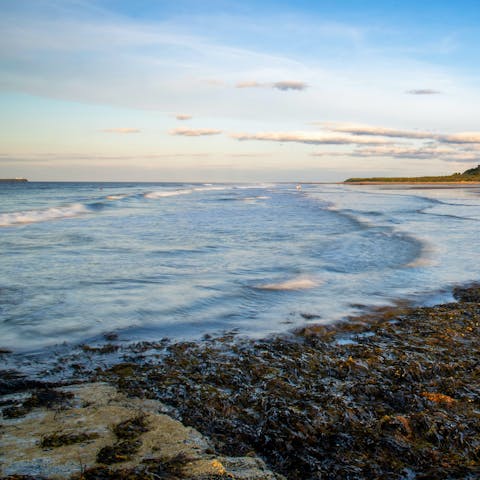 Enjoy wind-whipped walks along Bamburgh Beach, a short drive away