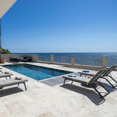 Lounge by the pool with a beachfront view front and centre
