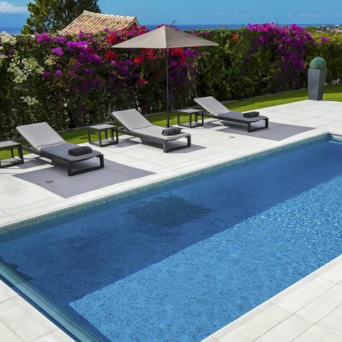 Watch the day drift by on a sun lounger by your pool