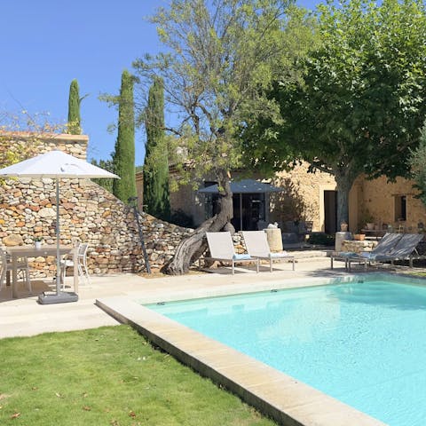 Chill by the pool on a sun lounger or at the shady table