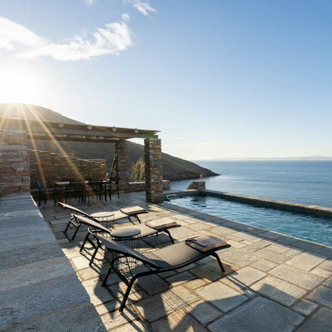 Lie back on a sun lounger and watch the rolling waves of the Aegean Sea
