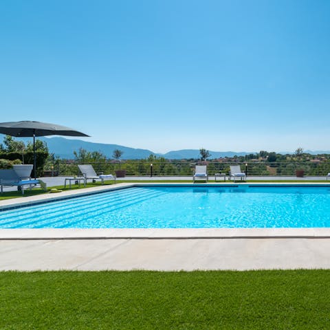 Glide through the home's swimming pool blessed with a rustic backdrop
