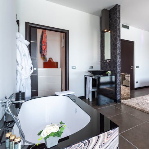 Sink back into soothingly warm water in the master bedroom's sleek bathtub
