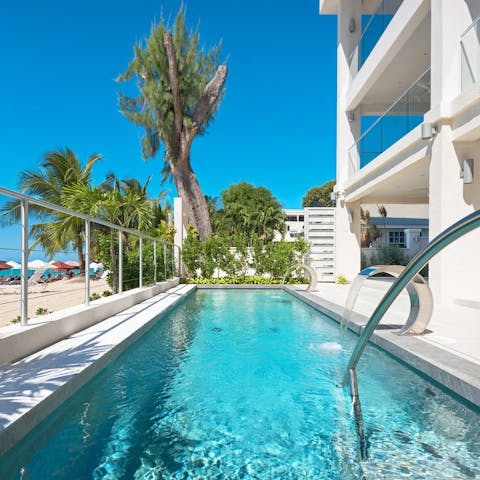 Swim in the private pool with the beach stretching before you