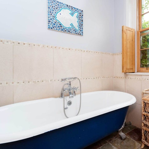 Take a well-deserved soak in the elegant freestanding bathtub