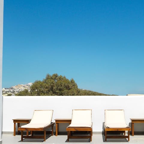 Sunbathe in the Santorini sunshine on the day beds