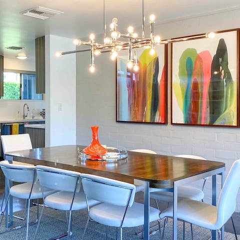 Enjoy a convivial meal under the light of the modern chandelier