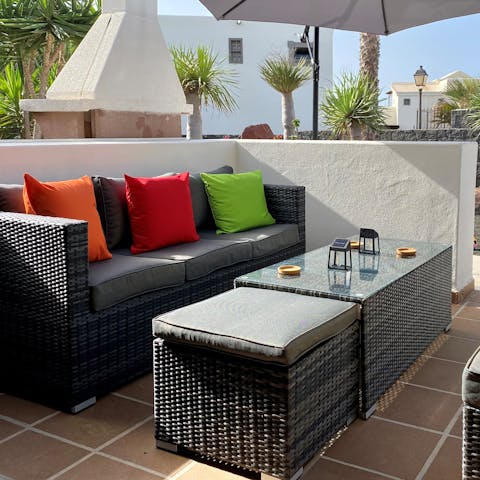 Enjoy some cocktails on the rattan-style sofa