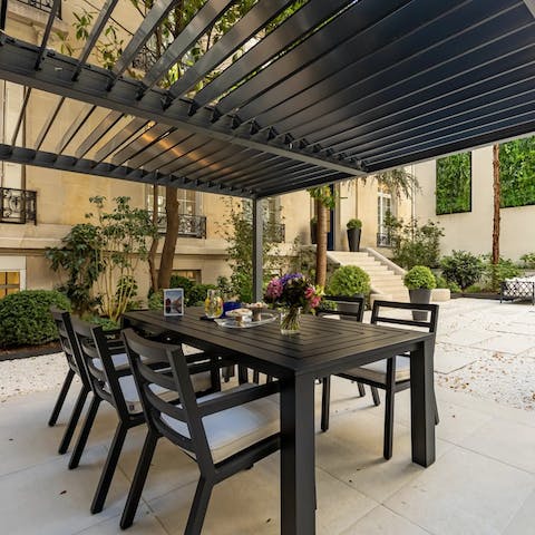 Set up for meals outside on the patio beneath the pergola