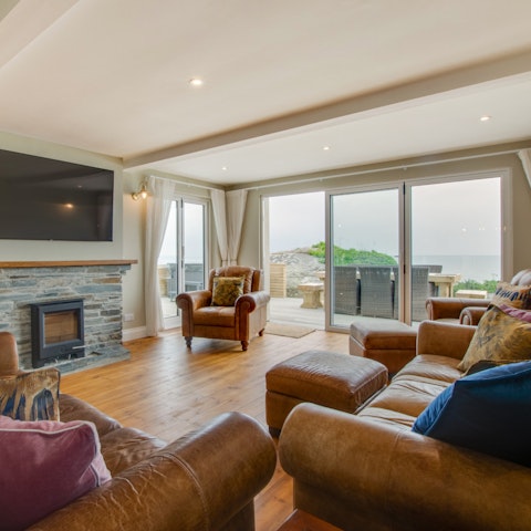 Cosy up on the brown leather sofas around a rustic wood-burning stove
