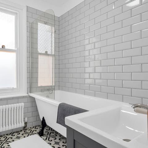 Relax in the freestanding bath tub in the sleek family bathroom