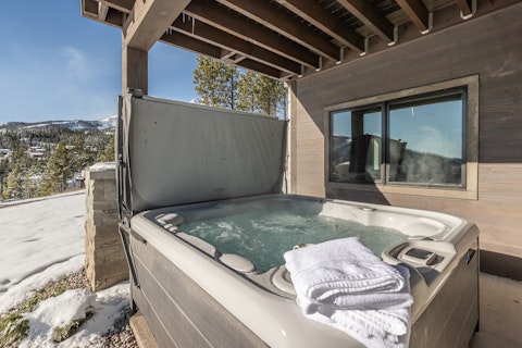 Soak in the hot tub with snow-dusted mountain peaks ahead