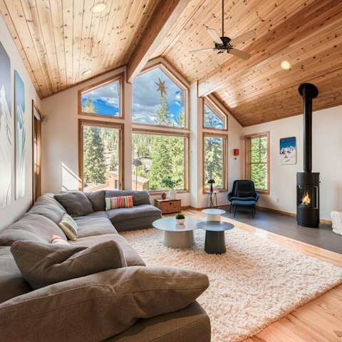 Gather in the living space, with forest views and a fireplace
