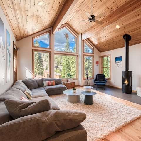 Gather in the living space, with forest views and a fireplace