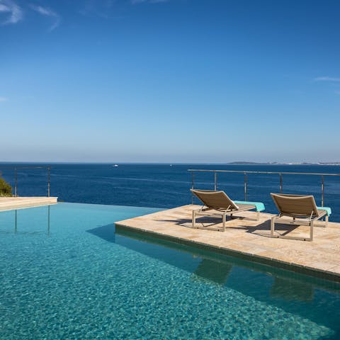 Watch the waves roll in from a poolside lounger