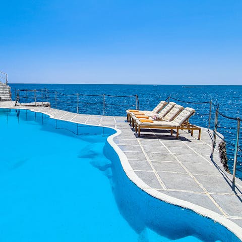 Spend serene days stretched out by the cliffside pool