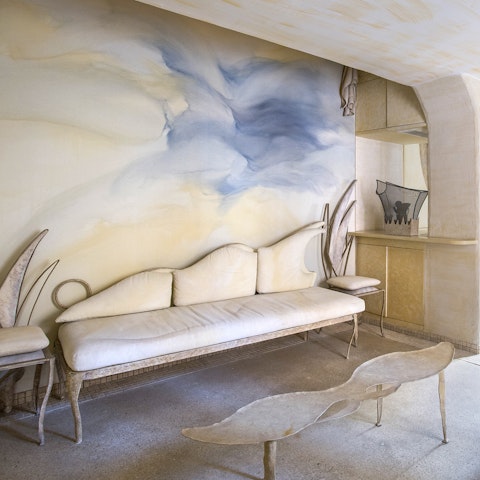 Relax in the serene living room with its cloudy sky wall