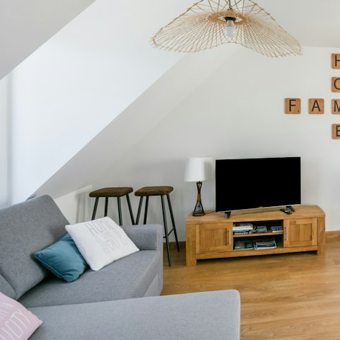 Relax and unwind in the bright living room, enjoying a glass of wine and a movie