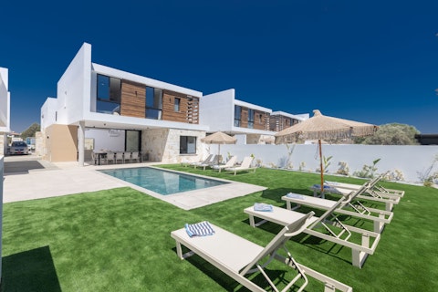 Stretch out on the lawn while the pool shimmers beside you