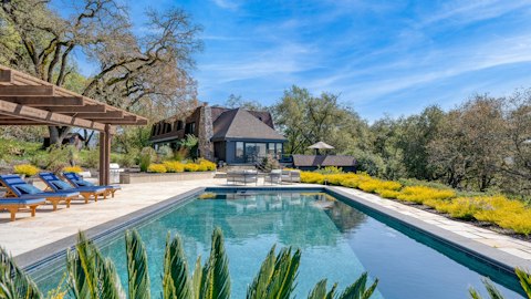 Swim laps framed by ancient oaks and golden hillside planting