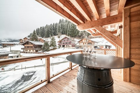 Sip wine from a barrel-top table with alpine village views