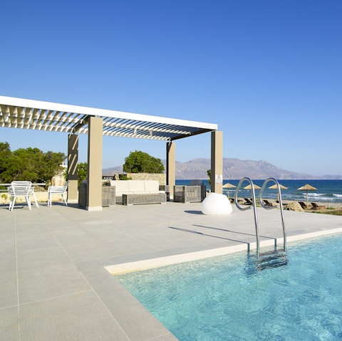 Lounge under parasols beside the Aegean