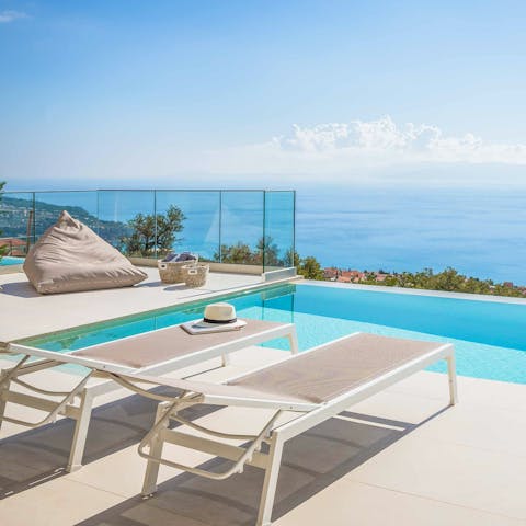 Enjoy views of the Ionian Sea while relaxing by the poolside