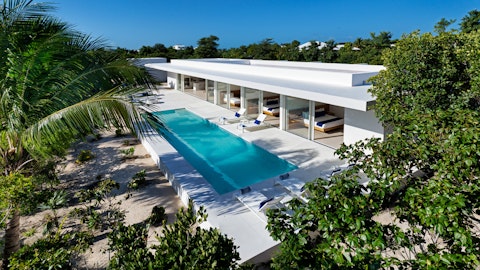 Swim laps in a gleaming pool framed by tropical greenery