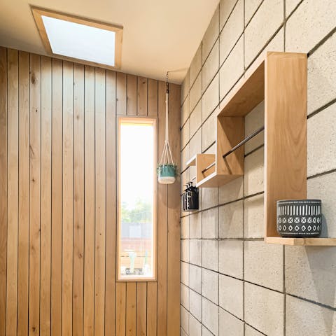 Enjoy a soak beneath the skylight in the wood shower