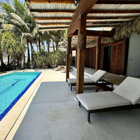 Lounge by the pool surrounded by palm trees