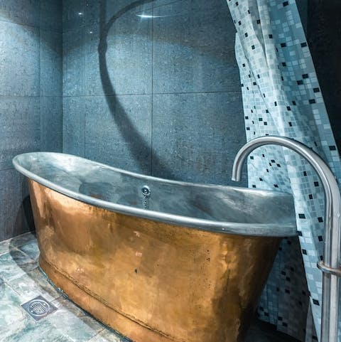 Slip into the freestanding bath to soak weary legs