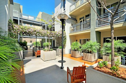 Step outside into a green, plant-filled courtyard with seating