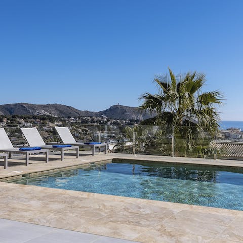 Lounge by the glistening pool and admire those stunning sea views