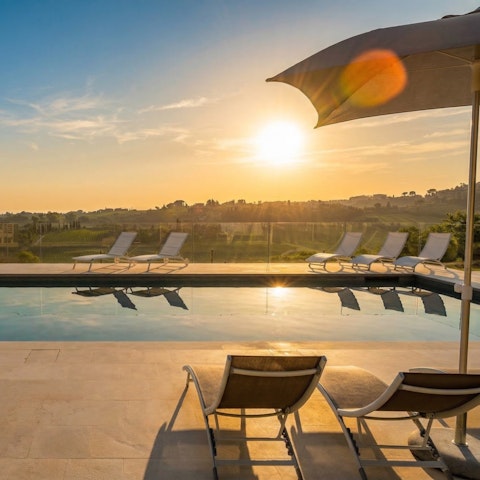 Stretch out poolside as the Tuscan hills glow at sunset