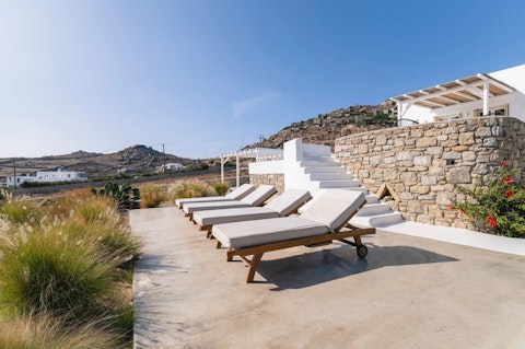 Stretch out on sun loungers overlooking the open hillside