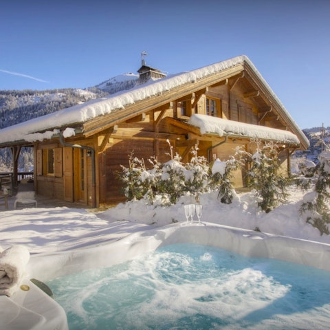 Soak in the hot tub as snow falls around you